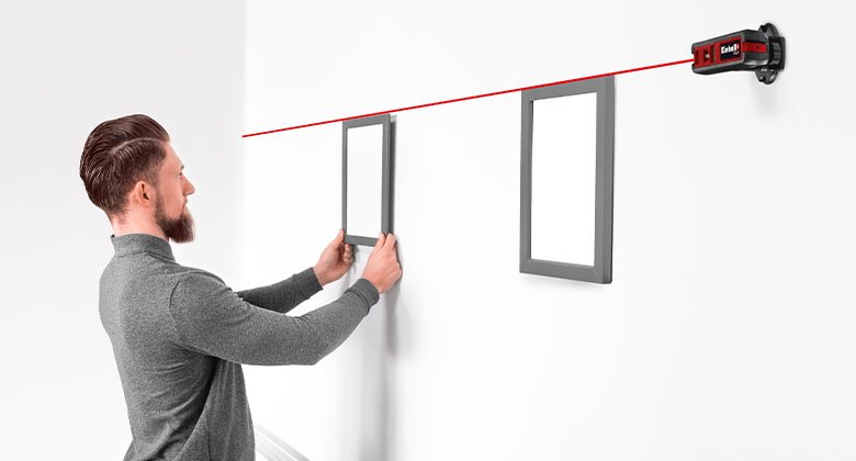 Man measuring a wall with a cross laser