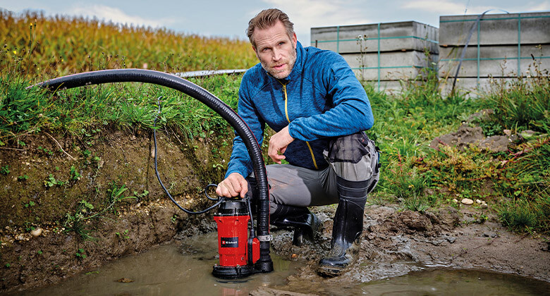 Man uses dirt water pump in a swamp